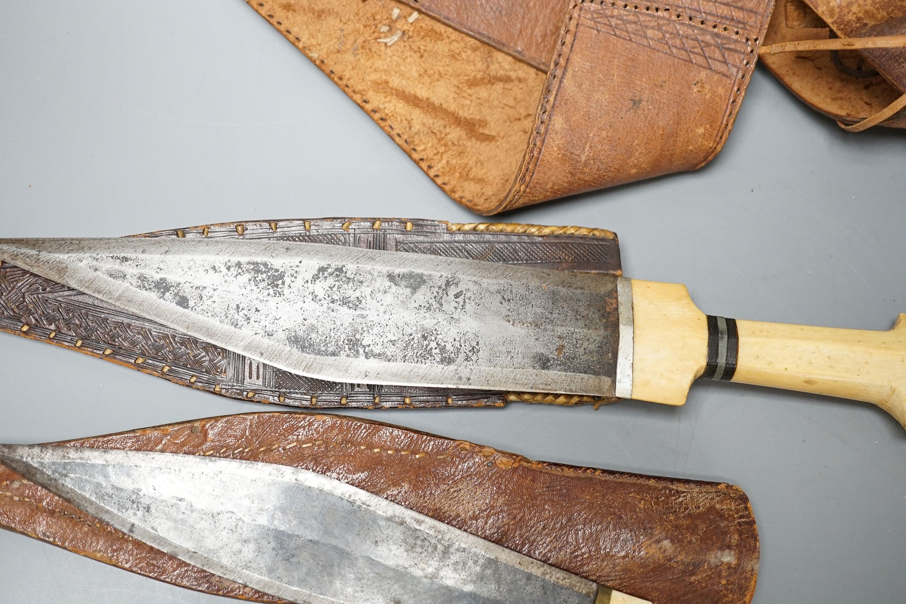 Four similar African tribal daggers c.1900, each with hippo tusk handle including two with silver pommels, all in their decorated leather scabbards with 1 belt, maximum 45cms.